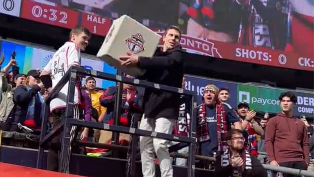 A New England Revolution fan preparing throw a box onto the field